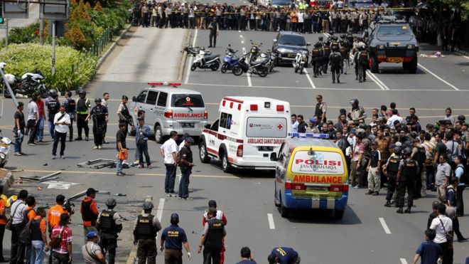 Машины скорой помощи индонезийской полиции передают толпы людей, несущих пострадавших, в больницу после взрыва бомбы перед торговым центром в Джакарте, Индонезия, 14 января 2016 года