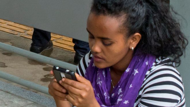 A woman looking at her phone in Ethiopia