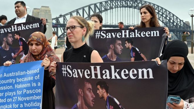 Протестующие держат таблички #SaveHakeem перед мостом через гавань Сиднея