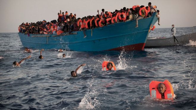 migrants from Eritrea jump into the water