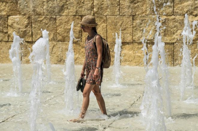 Женщина охлаждается в фонтане возле памятника Ара Пациса в центре Рима