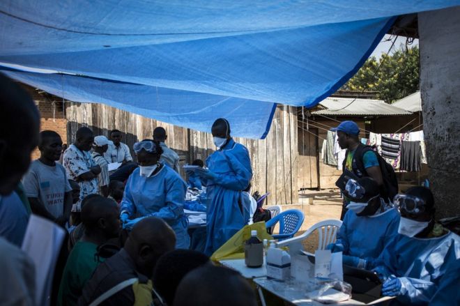Медицинские работники вводят вакцину против лихорадки Эбола 17 августа в Манджине