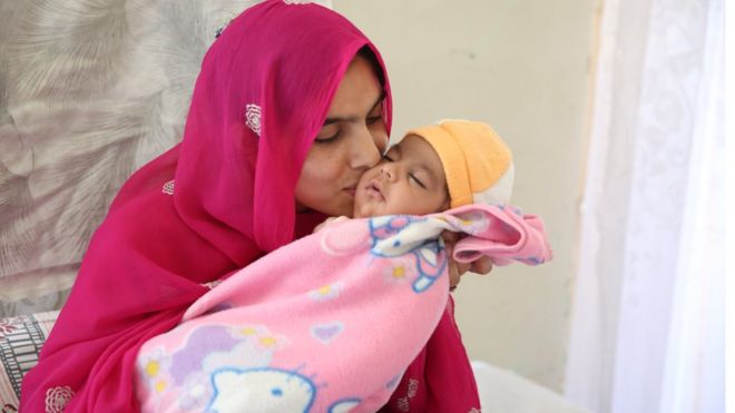Тайяба Анджум Али целует новорожденного сына