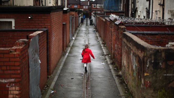 A young girl plays in an an alleyway in the Gorton area of Manchester