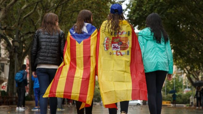 Jóvenes pasean en Figueres con la estelada y la bandera española.