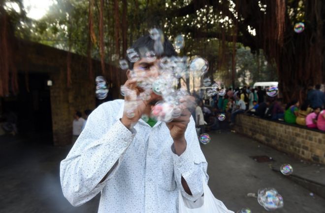 Безработный молодой индийский мужчина продает самодельное устройство для изготовления пузырей