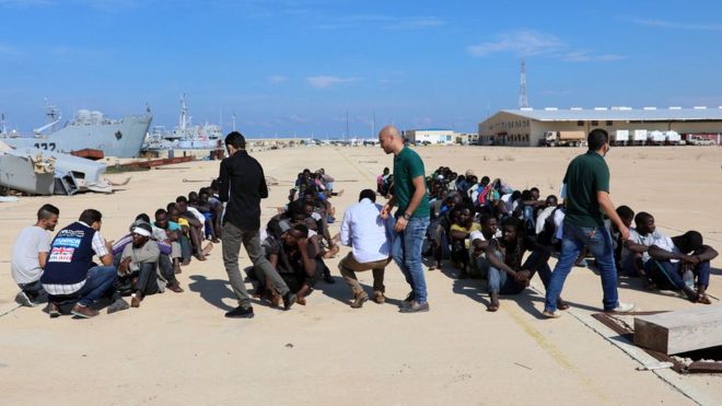Мигранты проверяются на военно-морской базе после того, как они были спасены ливийской береговой охраной в Триполи, Ливия