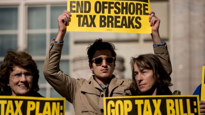 Люди протестуют против республиканского плана налоговой реформы возле Министерства торговли США 10 ноября 2017 года в Вашингтоне, округ Колумбия.