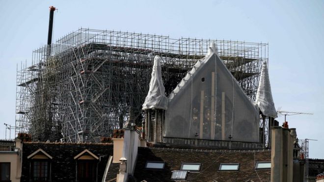 Розетка собора Нотр-Дам де Пари в Париже 22 апреля 2019 года покрыта защитным материалом через семь дней после пожара, опустошившего собор.