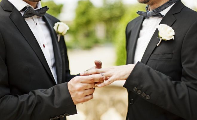 Гей-пара обменивается кольцами на свадьбе