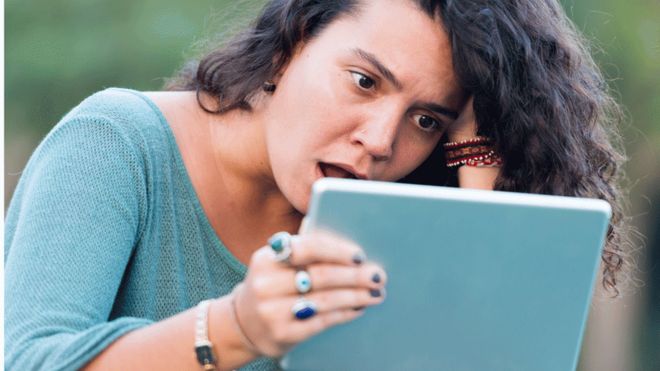 Woman looking at tablet in shock