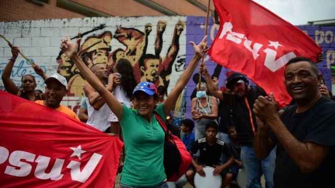 Сторонники президента Венесуэлы Николаса Мадуро демонстрируют, как активисты оппозиции идут к епископским местам католической церкви по всей стране, в Каракасе, 22 апреля 2017 года.