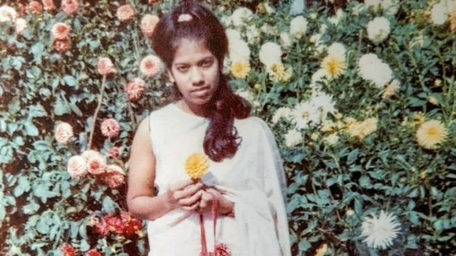 Рахима Сидхани позирует с цветком в образе молодой женщины после прибытия в Великобританию в 1969 году