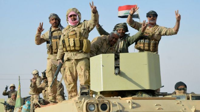 Iraqi forces make victory signs after capturing the town of Rawa on 17 November 2017