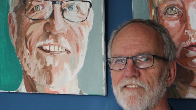 Владелец кофейни Бринмилл Рики Миллер стоит у своего портрета, сделанного Симусом Джонстоном