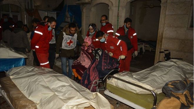 Девушка в инвалидной коляске, которую врачи Красного Креста и Красного Полумесяца отталкивают через кровати с трупами в доме престарелых в восточной части Алеппо, среда, 7 декабря 2017 года