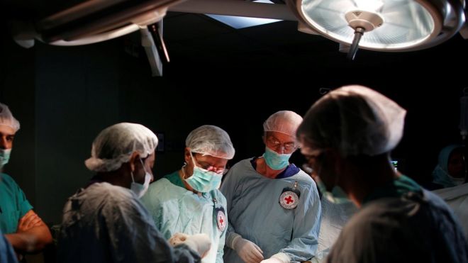 Британский сосудистый хирург Джон Вулф, который был приглашен в Газу Международным комитетом Красного Креста (МККК), проводит операцию для раненого палестинца в операционной комнате в больнице в городе Газа 25 апреля 2018 года