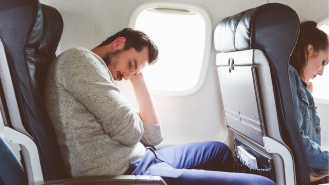 Un hombre duerme en un avión