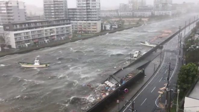 Лодки плавают вместе с обломками во время тайфуна Джеби в городе Нишиномия