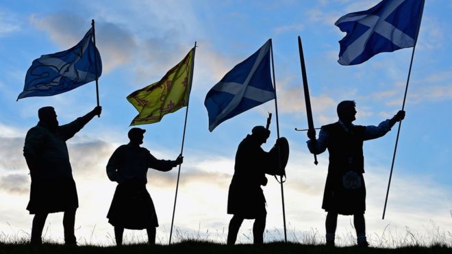 Дункан Томсон, Брайан Маккатчон, Джон Паттерсон и Артур Мердок из Общества королей шотландцев Роберта Брюса держат шотландские флаги во время подготовки к голосованию на референдуме о независимости Шотландии 14 сентября 2014 года в Лох-Ломонд.