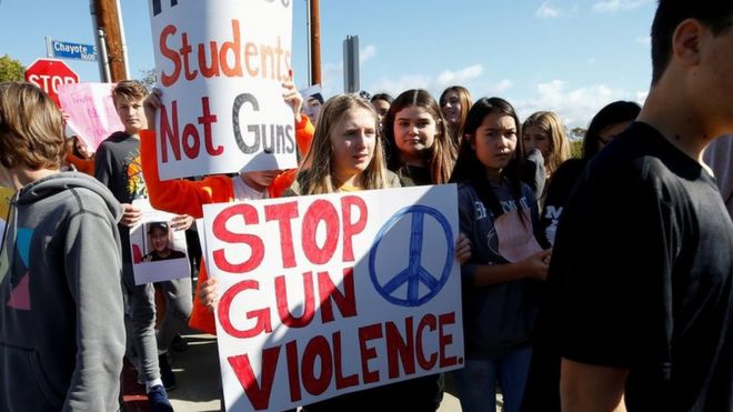 Студенты с плакатами и демонстрацией против насилия с применением оружия в США