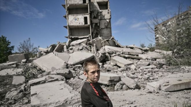 A young boy stands in front of a damaged building after a strike in Kramatorsk in the eastern Ukranian region of Donbas, on May 25, 2022.