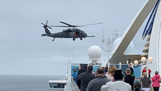 A helicopter hovers above the Grand Princess cruise ship, 5 March