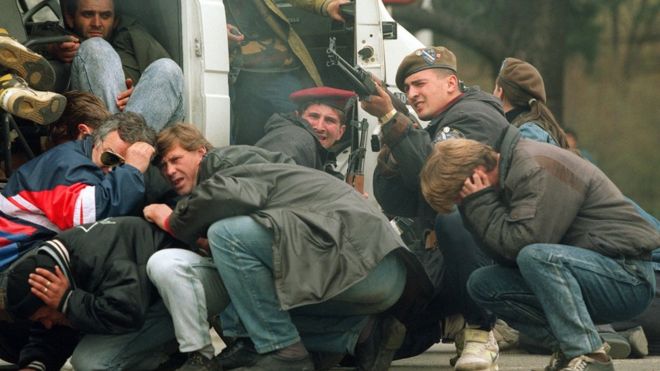 Гражданские лица и боснийские войска под обстрелом сербских снайперов во время осады Сараево в 1992 году