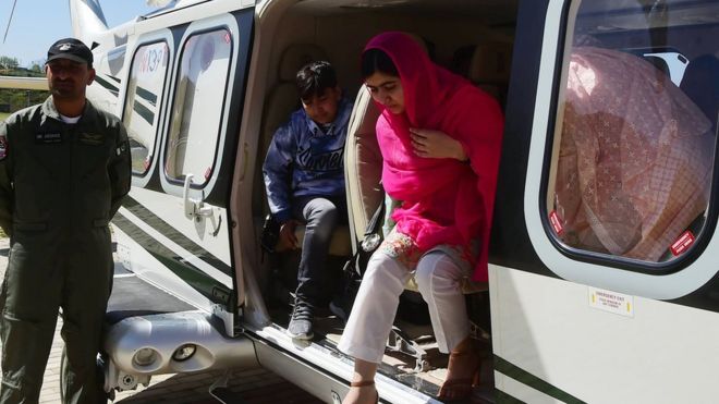 Малала выходит из военного вертолета, который доставил ее в ее родной город в долине Сват в Пакистане