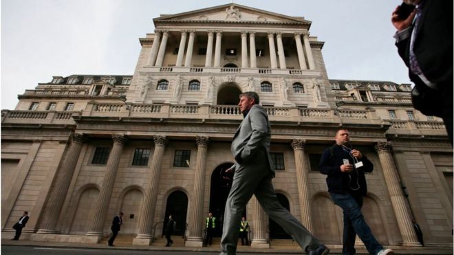 People walk past the Bank of England