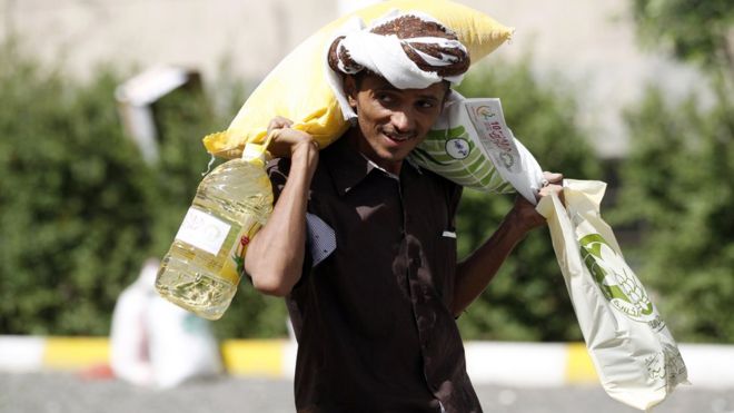 رجل يمني يحمل مساعدات غذائية قدمتها له منظمة خيرية محلية في العاصمة صنعاء