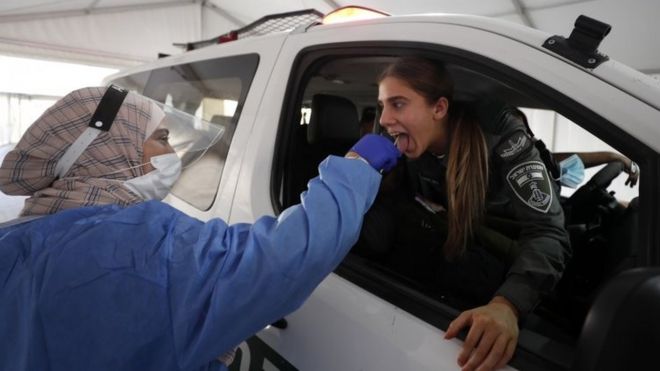 A woman is tested in Israel for Covid