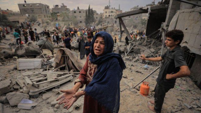 Una mujer muestra sus manos vacías en medio de los escombros que dejaron los bombardeos de Israel