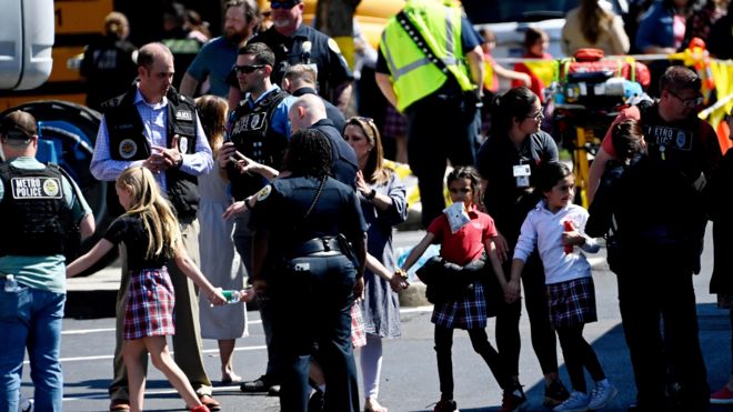 Alunos da Covenant School de mãos dadas depois de descer de um ônibus após um tiroteio em massa em Nashville