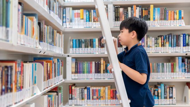 Un niño en una escalera en una biblioteca