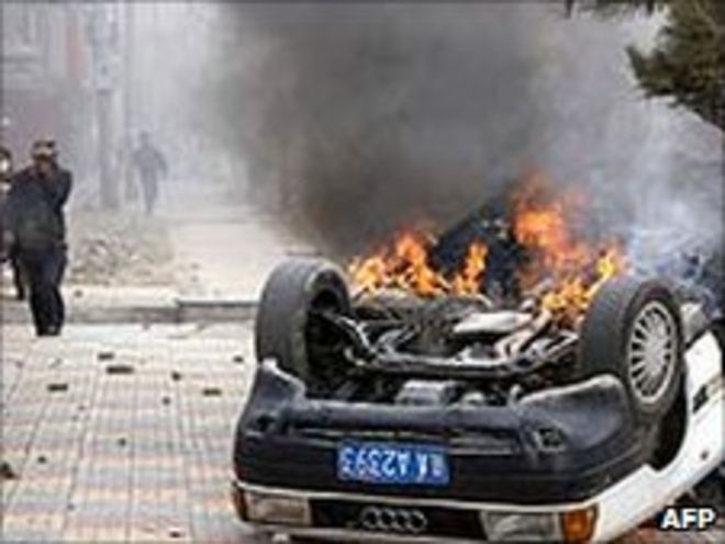 Горящая машина в тибетской столице Лхасе после протестов (март 2008 г.)