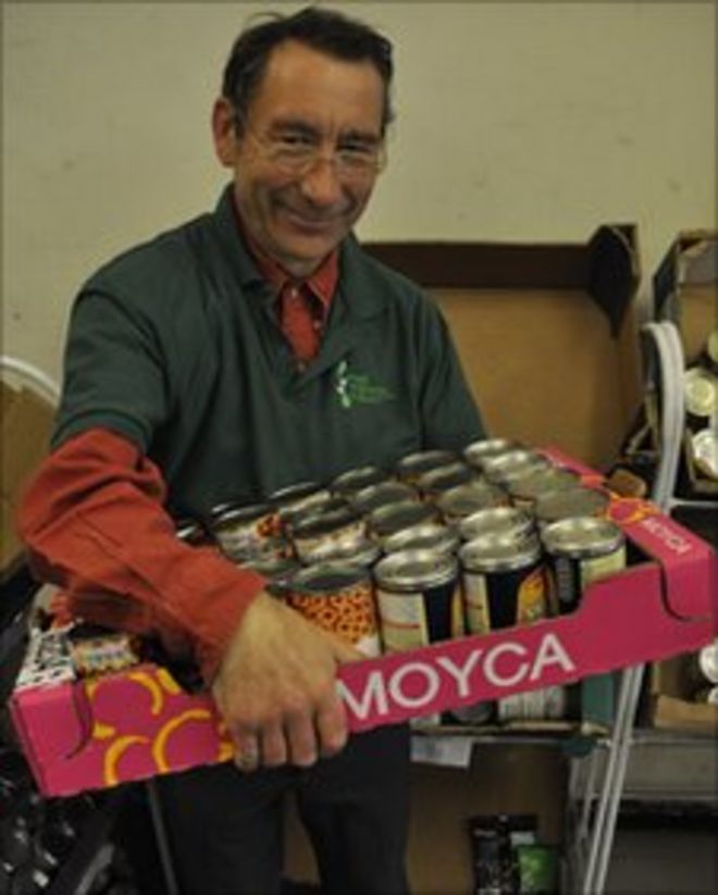 Волонтер Foodbank Питер Мосс с консервированными продуктами