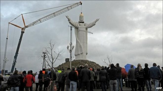 People watch as a crane lifts into place the statue's head in Swiebodzin. Photo: 6 November 2010