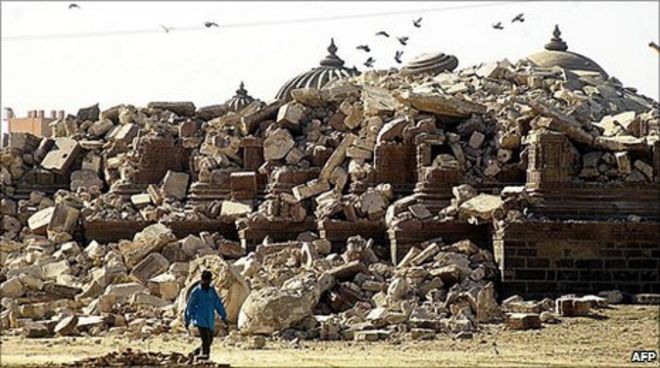 Мужчина проходит мимо развалин исторического религиозного памятника, который рухнул в городе Бхудж в Гуджарате в январе 2001 года