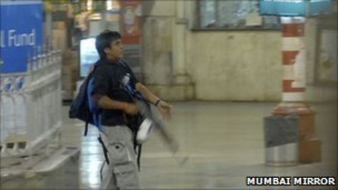 На этой фотографии, сделанной 26 ноября 2008 года, вооруженный человек, которого полиция опознала как Аджмала Касаба, ходит по железнодорожной станции Терминал Чатрапати Шиваджи в Мумбаи, Индия