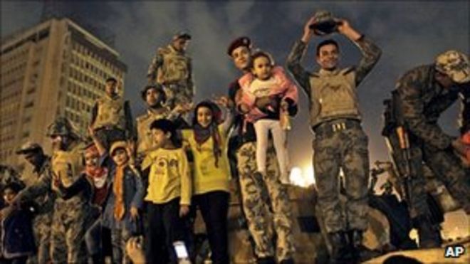 Солдаты египетской армии празднуют с детьми на своем бронетранспортере на площади Тахрир, Каир, 11 февраля 2011 года
