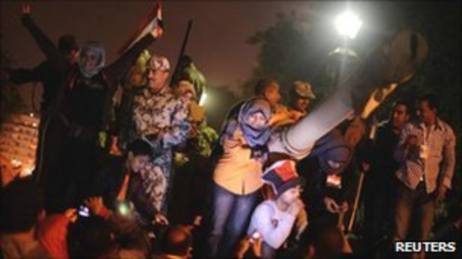 Египетские демонстранты празднуют с солдатами на вершине танка на площади Тахрир, Каир, 11 февраля 2011 года