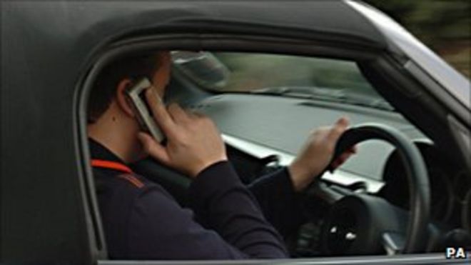 Человек, использующий мобильный телефон в машине