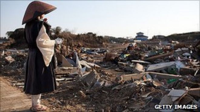 Буддийская монахиня Джикоу Йошида молится на месте разрушенного цунами города Минамисанрику
