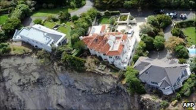 На снимке, сделанном 27 февраля 2011 года, изображены роскошные дома, стоящие на краю после оползней на Красных скалах возле Крайстчерча после землетрясения силой 6,3 балла, которое опустошило второй город Новой Зеландии и окружающие города, убив 18 февраля 221 человек