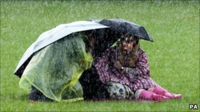 Укрытие под зонтиками на музыкальном фестивале T in the Park в Шотландии