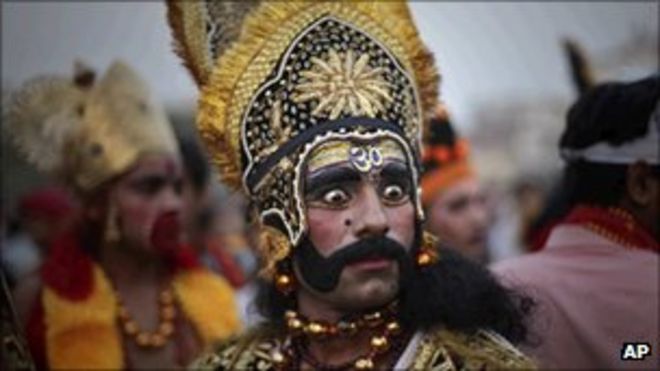 Индус-индус, одетый как король демонов Равана, смотрит на место проведения гулянья в Душере