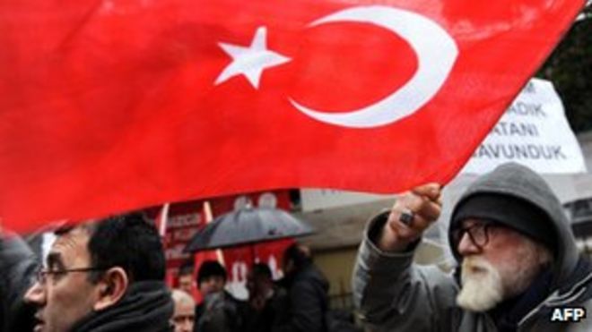 Мужчина машет турецким флагом, принимая участие в митинге перед французским консульством в Стамбуле