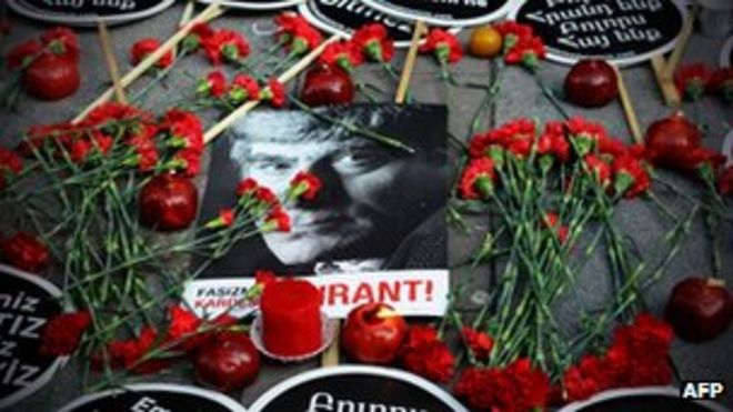 Красные гвоздики окружают фотографию Гранта Динка возле редакции газеты Agos в Стамбуле, 19 января