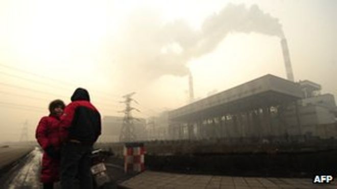 Два человека разговаривают возле угольной электростанции в Линьфэнь, провинция Шаньси.